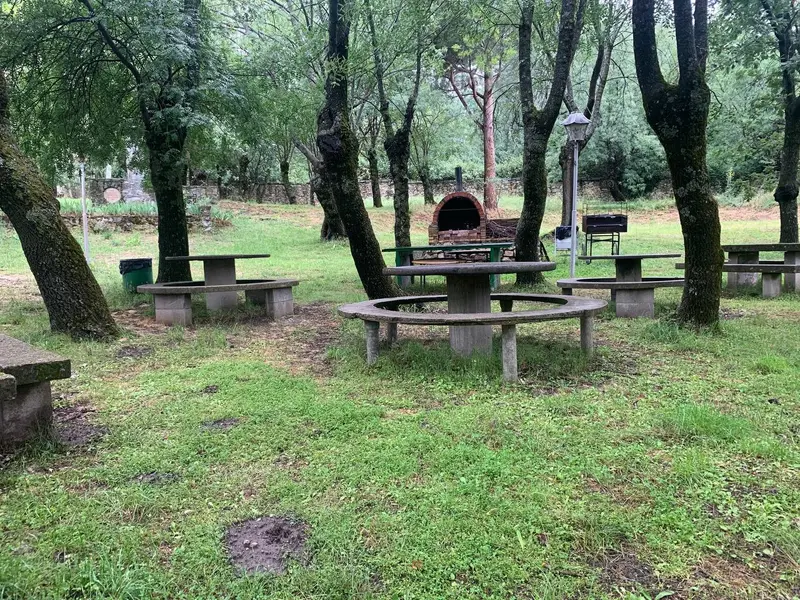 Mesa redonda con un banco circular bajo los árboles en el lugar del retiro, en San Lorenzo de El Escorial